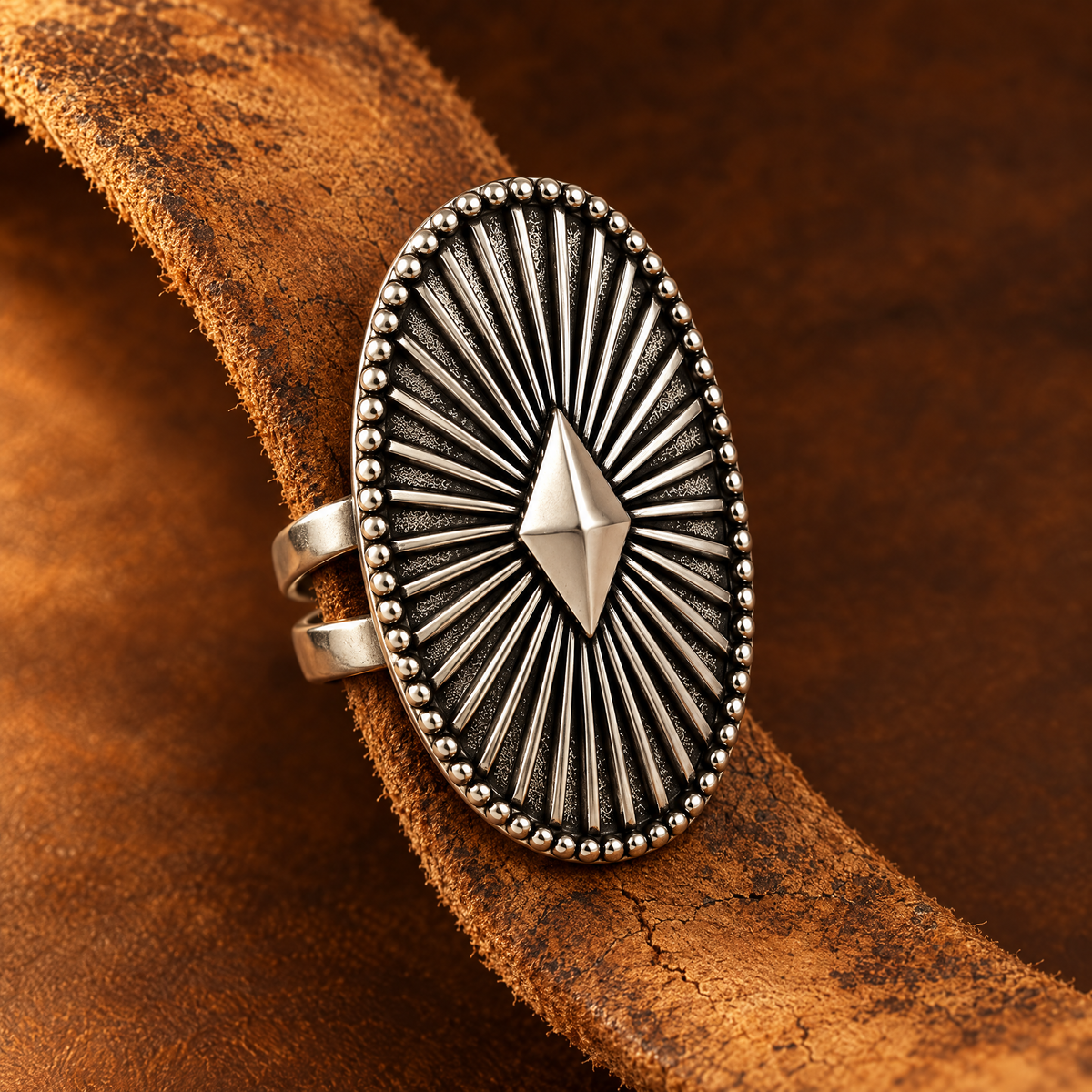 Shield Star Ring close-up on worn tan leather strip