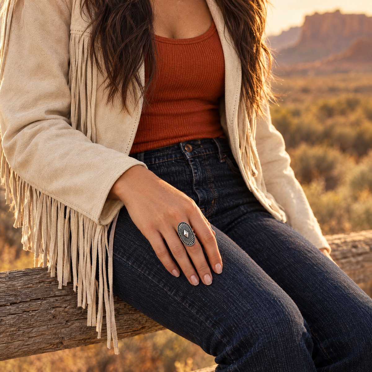 Shield Star Ring worn on hand resting on thigh with suede fringe jacket on a ranch fence