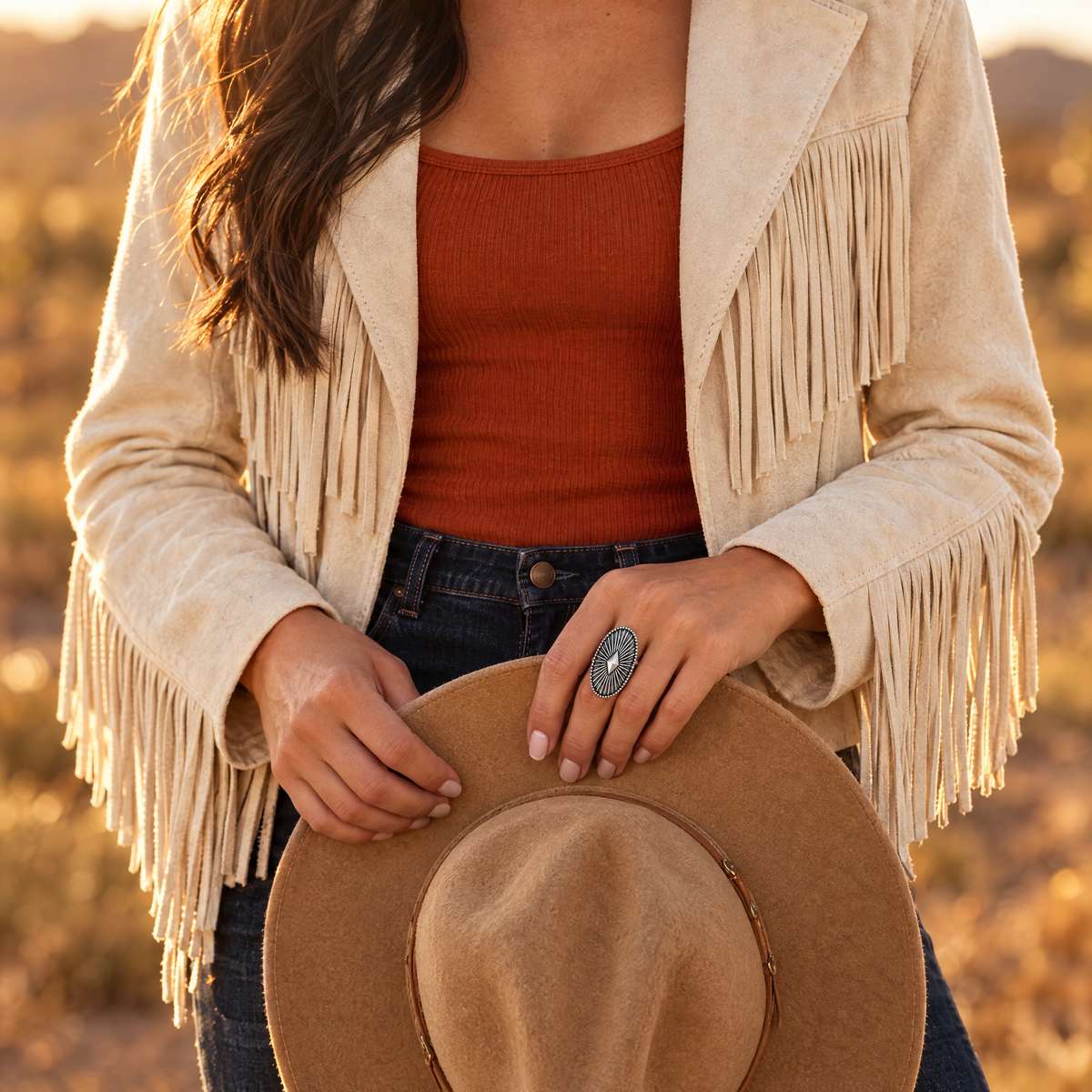 Shield Star Ring on hand holding a cowboy hat brim at golden hour