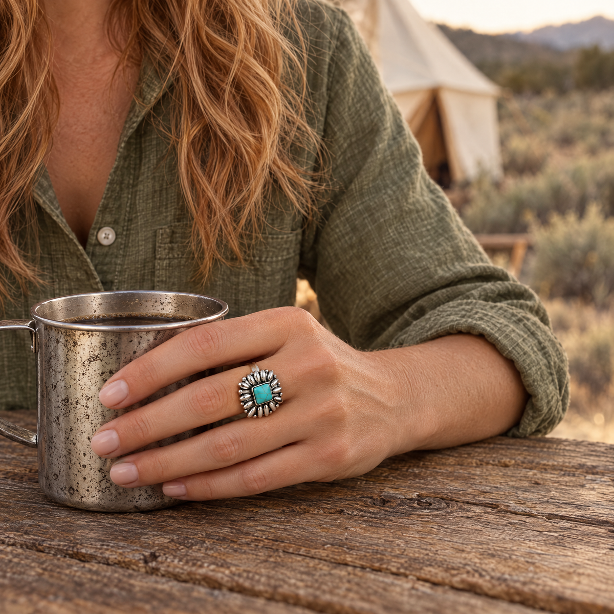 Silver Blossom Ring on hand holding a tin coffee cup at a ranch camp table