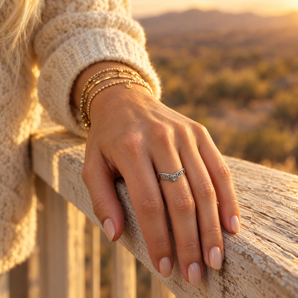 Cowgirl Wishbone Ring worn on hand resting on a wooden porch railing
