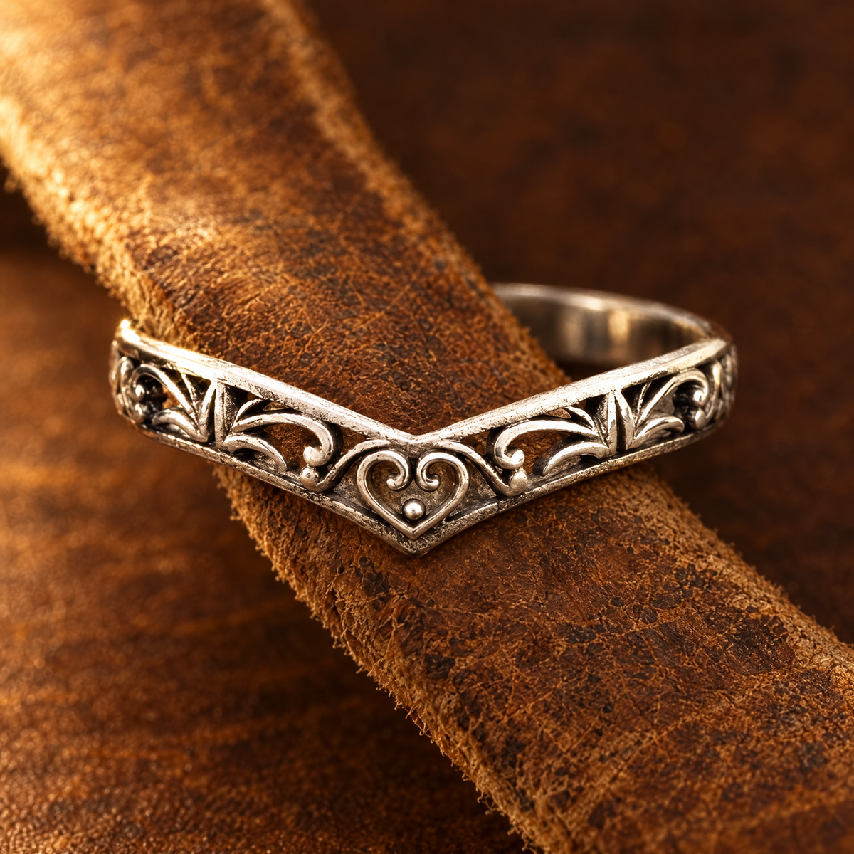 Cowgirl Wishbone Ring threaded on a strip of tan cowhide leather